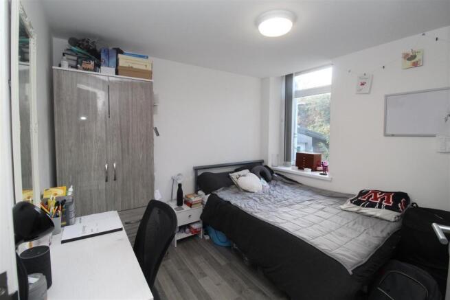 Bright bedroom with large desk and ample storag...