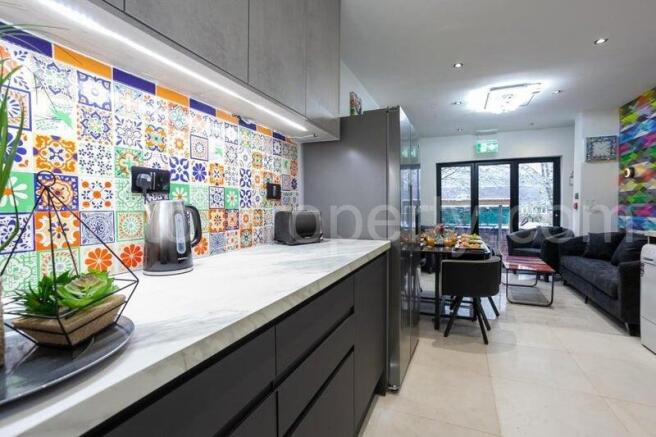 Stylish open-plan kitchen with modern grey cabi...