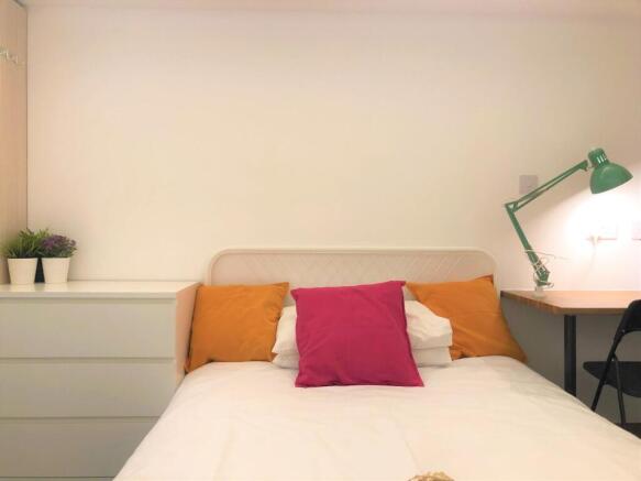 A cozy single bedroom featuring a neatly made b...