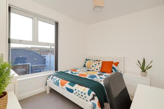 A bright and tidy double bedroom featuring a co...