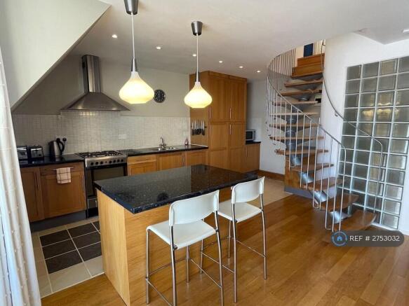Kitchen And Feature Staircase To Upper Floor