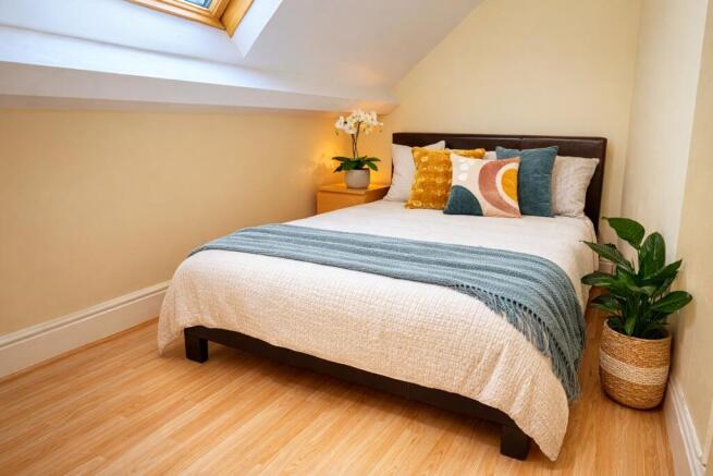 Bright, neatly styled bedroom with a comfortabl...