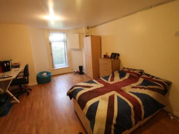 A cozy single bedroom featuring a bed with a Un...