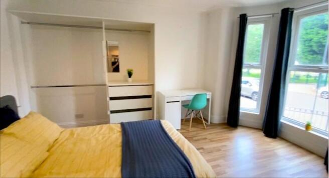 Bright, modern bedroom with large windows and b...