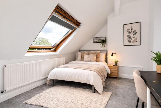 Bright attic bedroom with large skylight window...