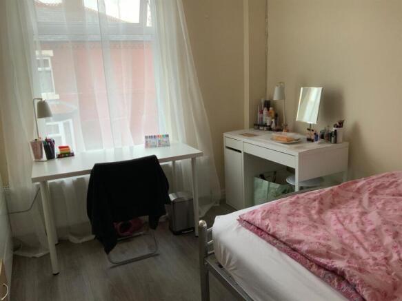 Bright, simply furnished bedroom with a double ...