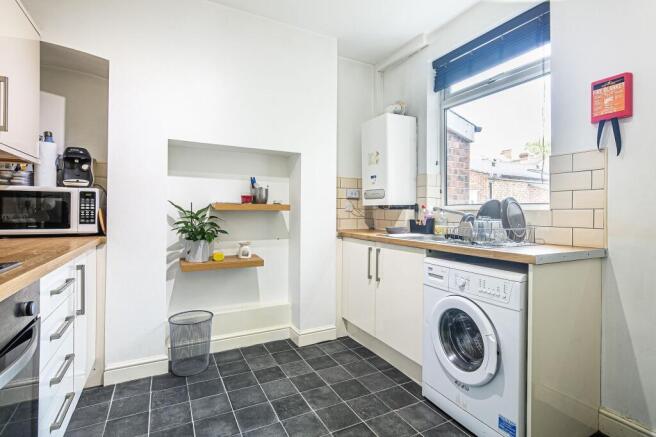 Bright, modern kitchen with wooden worktops, ti...