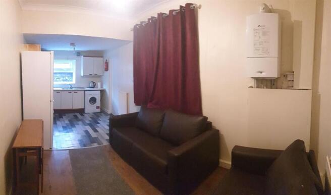 Compact open-plan living area with two black so...