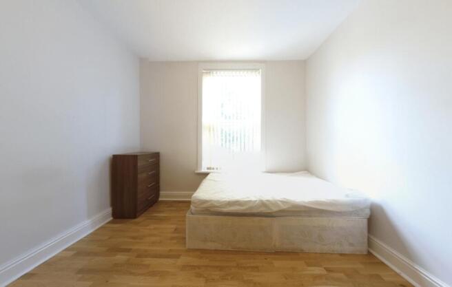 A bright and minimalist bedroom featuring a lar...