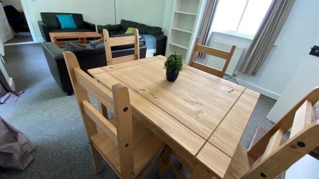 Bright communal lounge with dining table and so...