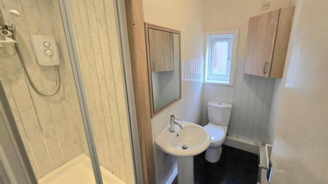 Compact bathroom with shower and white fixtures...