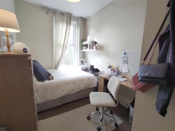 Bright, neatly arranged bedroom with a comforta...