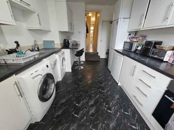 Long galley kitchen with matching white cabinet...