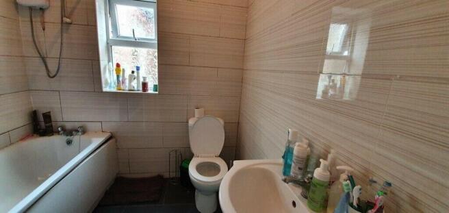 Bright tiled bathroom with full bath and window...