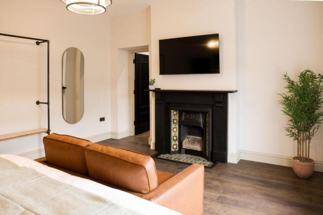 Stylish master bedroom with fireplace and TV...