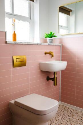 Bright, stylish WC with pink tiled walls, terra...