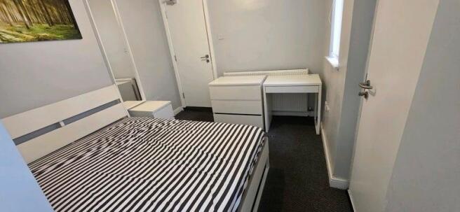 Bright, modern bedroom with desk and storage...