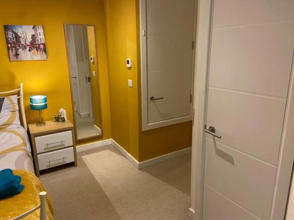 Brightly painted bedroom with a cosy bedside ta...