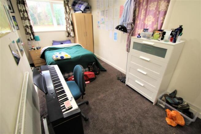 Bright single bedroom with a double bed dressed...