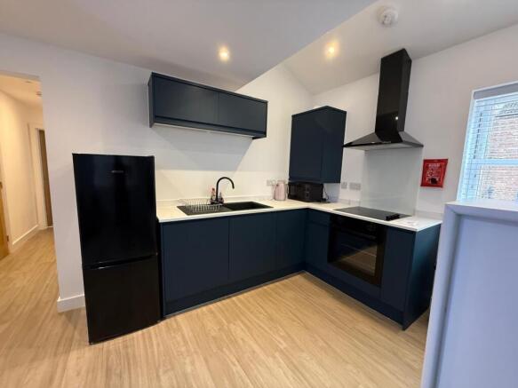 Contemporary galley-style kitchen with sleek da...