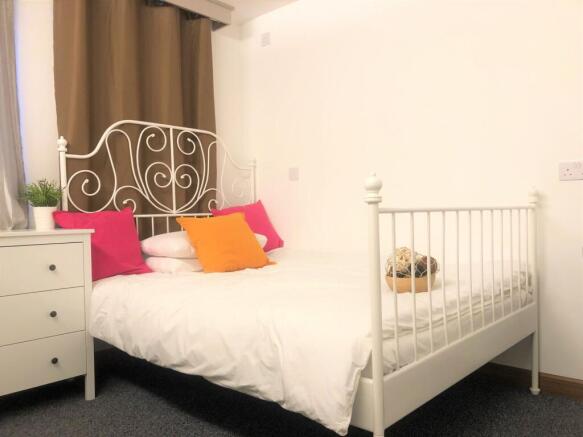 A bright and inviting double bedroom featuring ...