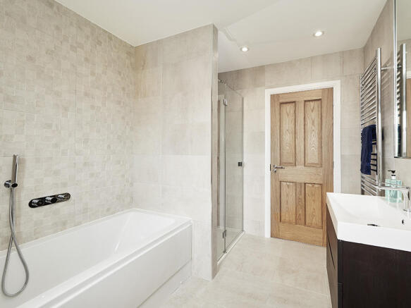 Extensively tiled family bathroom with separate shower