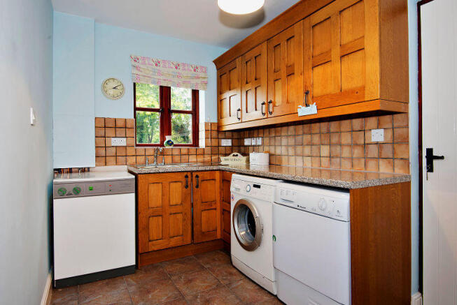 Laundry with solid oak cabinets.