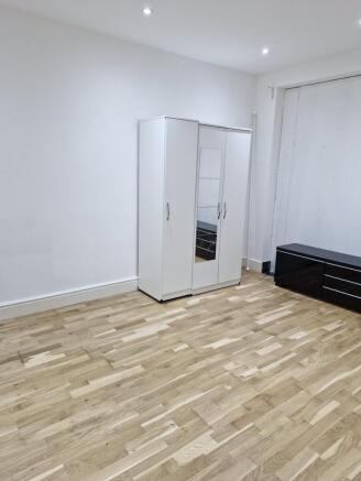 Spacious room with modern flooring and storage...