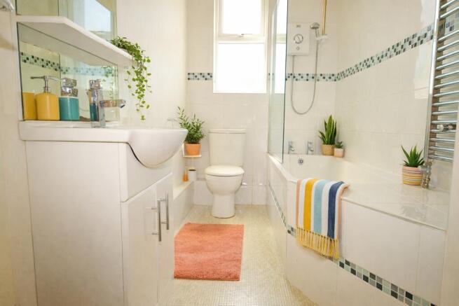 Bright, modern bathroom with a bath-shower, whi...