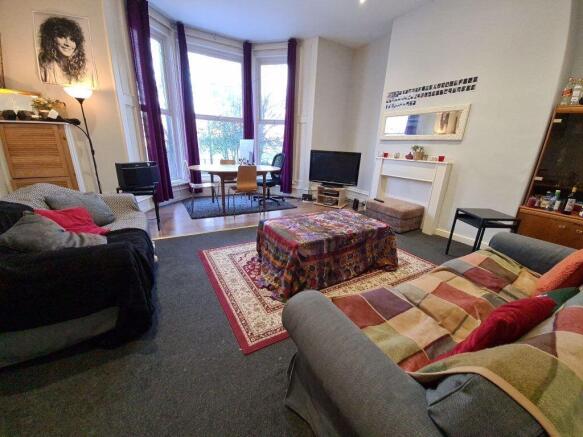 A spacious and well-lit living room featuring c...