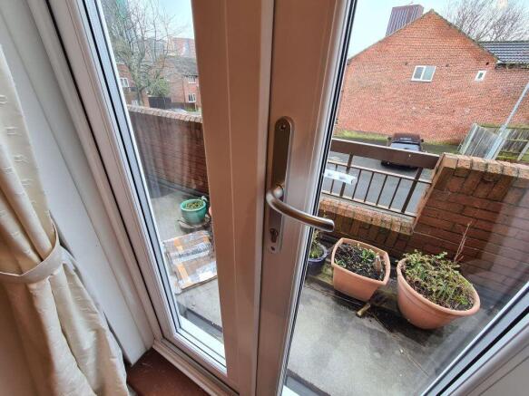 A small, sunny outdoor garden space featuring p...