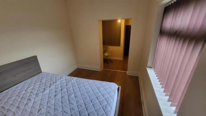 Bright, simply furnished bedroom with a double ...