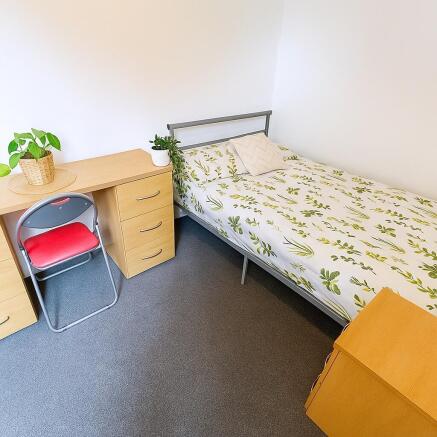 Neat single bedroom with a metal-framed bed dre...