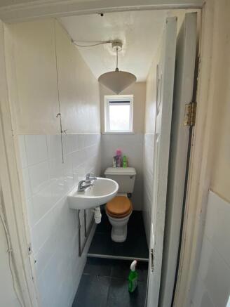 Bright, clean toilet with convenient hand basin...