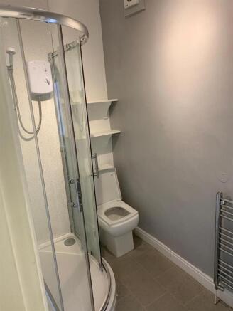 Modern bathroom with a curved glass shower encl...