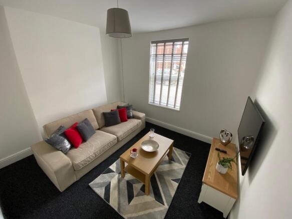 Bright, neatly furnished living room with a com...