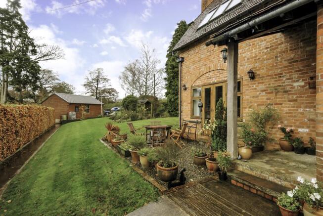 Garden view leading to double garage and parking