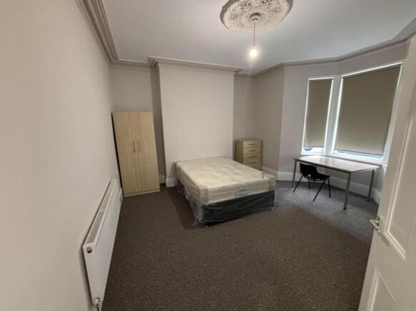 A spacious and well-lit double bedroom perfect ...