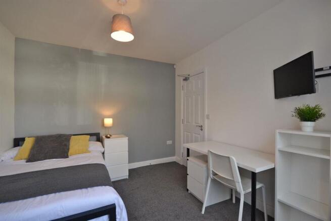 Bright modern bedroom with study desk and TV...