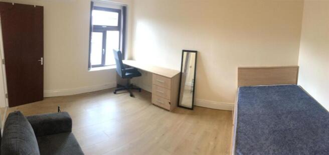 Bright, spacious bedroom with desk and sofa...