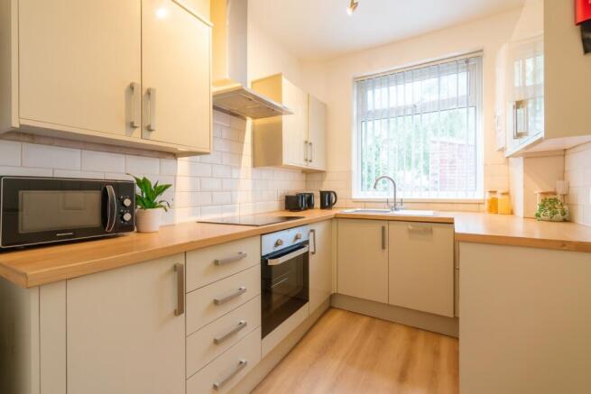 Bright, modern kitchen with light wood worktops...