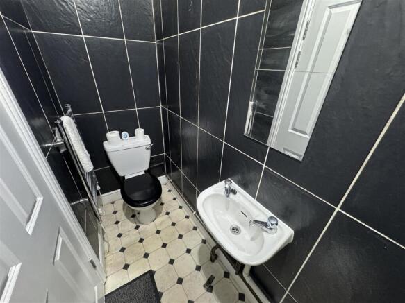 Modern tiled washroom with stylish black walls...