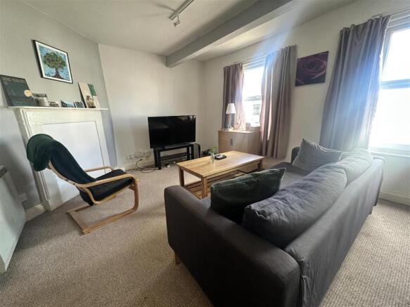 Bright lounge with comfy sofa and large TV....