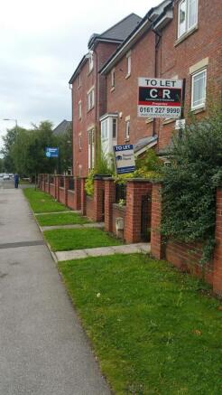 Red-brick terraced property with small front la...
