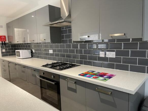 A modern and spacious kitchen with sleek grey c...