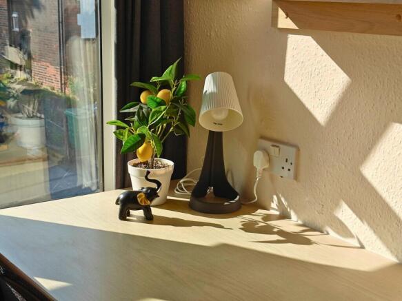 Sunlit workspace by a large window with a tidy ...