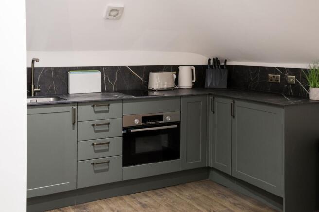 Modern fitted kitchen with dark countertops...