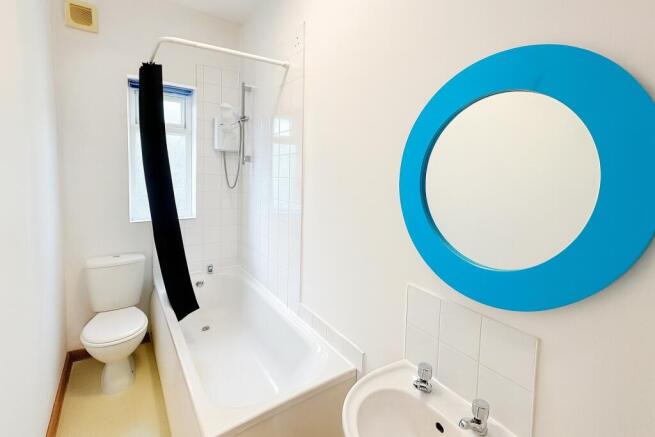 Bright, freshly painted bathroom with a white b...
