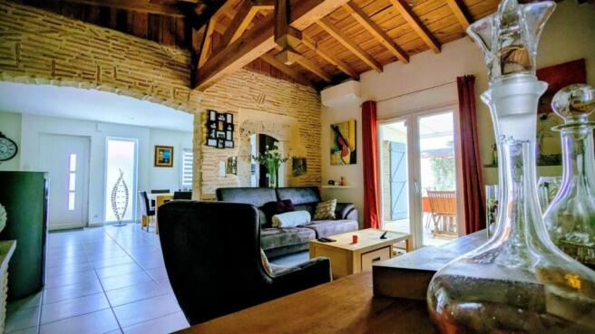 Un salon chaleureux avec un plafond en bois, une l