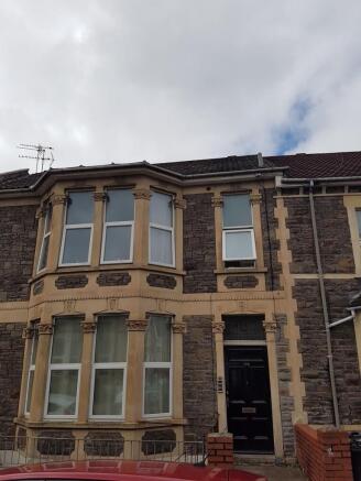 Traditional stone-fronted home with bay windows...
